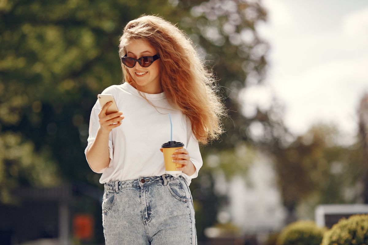 Woman enjoying coffee outdoors in a sunny park